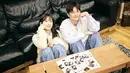 Dalam foto teaser, Seo In Guk dan Jung Eun Ji tampil dengan konsep yang sangat selaras dengan judul lagu, yaitu 'Couple'. Keduanya terlihat serasi mengenakan pakaian rajut dan celana jeans, duduk berdampingan di sofa sambil tersenyum hangat. (Liputan6.com/IG/@epmusic.official)