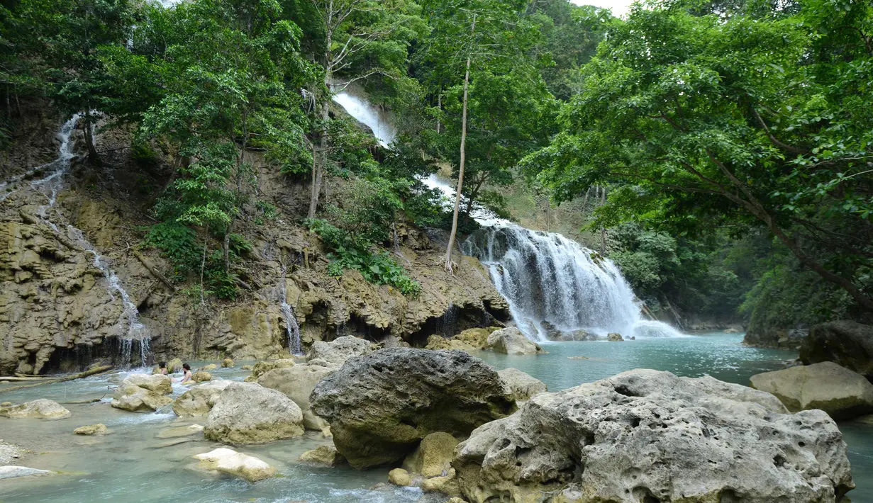 Wisatawan menikmati Air Terjun Lapopu yang terletak di Desa Hatikuloku, Kecamatan Wanokaka, Kabupaten Sumba Barat, NTT (21/10). Keunikan air terjun ini bentuknya berundak-undak tak seperti air terjun umumnya. (AFP Photo/Sony Tumbelaka)