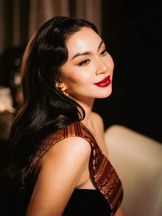 Wajahnya tampak diaplikasikan complexion matte finish dan kontur wajah tegas. Aplikasi eyeshadow warna coklat kemudian diaplikasikan pada kelopak matanya. [@arieltatum]