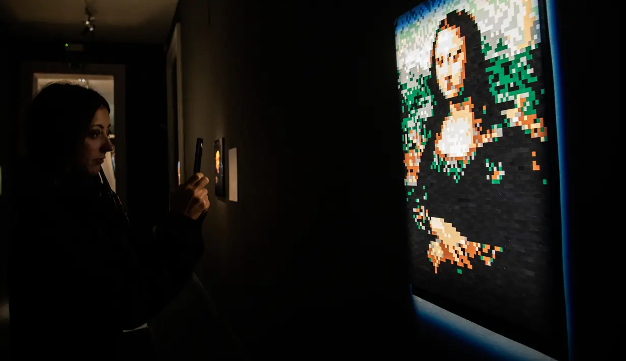Pengunjung mengambil gambar patung "Mona Lisa" yang terbuat dari susunan balok lego pada pameran Art of the Brick di Turin, Italia, Kamis (15/11). Pameran tersebut menampilkan berbagai patung lego karya seniman AS, Nathan Sawaya. (MARCO BERTORELLO/AFP)