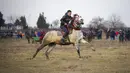 Seorang pria menunggang kuda saat perayaan Epiphany di Desa Pietrosani, Rumania, 6 Januari 2022. Epiphany adalah sebuah hari raya keagamaan dalam sejumlah denominasi gereja Kristen pada tanggal 6 Januari. (AP Photo/Vadim Ghirda)