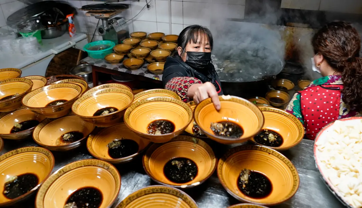 Aktivitas pekerja sebuah restoran mi di wilayah Xiushan, Chongqing, China barat daya, Jumat (27/2/2020). Kegiatan produksi dan kehidupan sehari-hari warga berangsur normal berkat upaya pengendalian virus corona COVID-19 yang efektif di Xiushan. (Xinhua/Liu Chan)