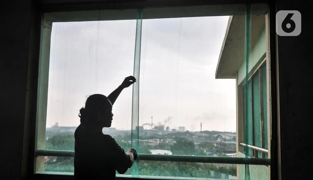 Warga memasang jaring sebagai antisipasi mengurangi pencemaran debu batu bara di Rusunawa Marunda, Jakarta Utara, Rabu (9/3/2022). Saat ini Dinas Lingkungan Hidup DKI Jakarta tengah menyelidiki sumber polusi debu batu bara yang diduga dari industri setempat. (merdeka.com/Iqbal S. Nugroho)