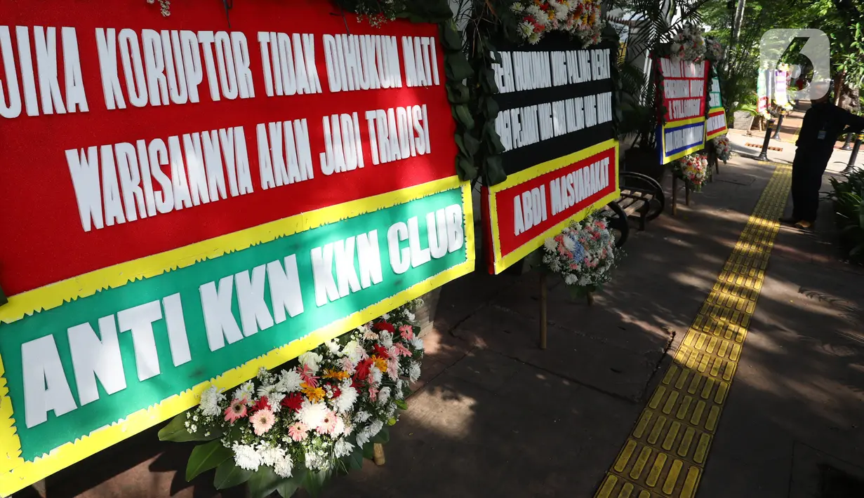 Petugas keamanan mengamati sejumlah karangan bunga yang terpajang di depan PN Jakarta Pusat, Senin (12/10/2020). Karangan bunga yang mengharapkan keadilan tersebut berjejer menjelang sidang vonis terdakwa kasus dugaan korupsi di PT Asuransi Jiwasraya (Persero). (Liputan6.com/Angga Yuniar)