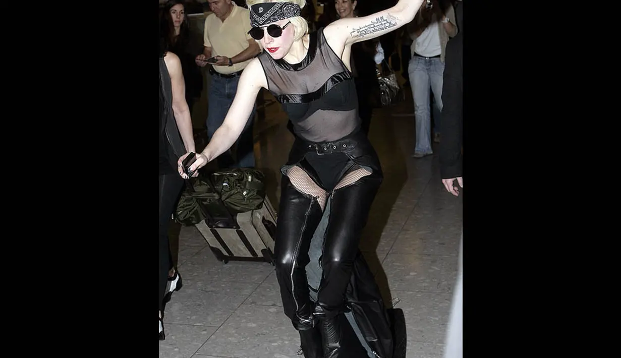 Mengenakan sepatu berhak tinggi berbentuk aneh membuat penyanyi nyentrik Lady Gaga terjatuh di bandara Heathrow. (INFphoto.com)