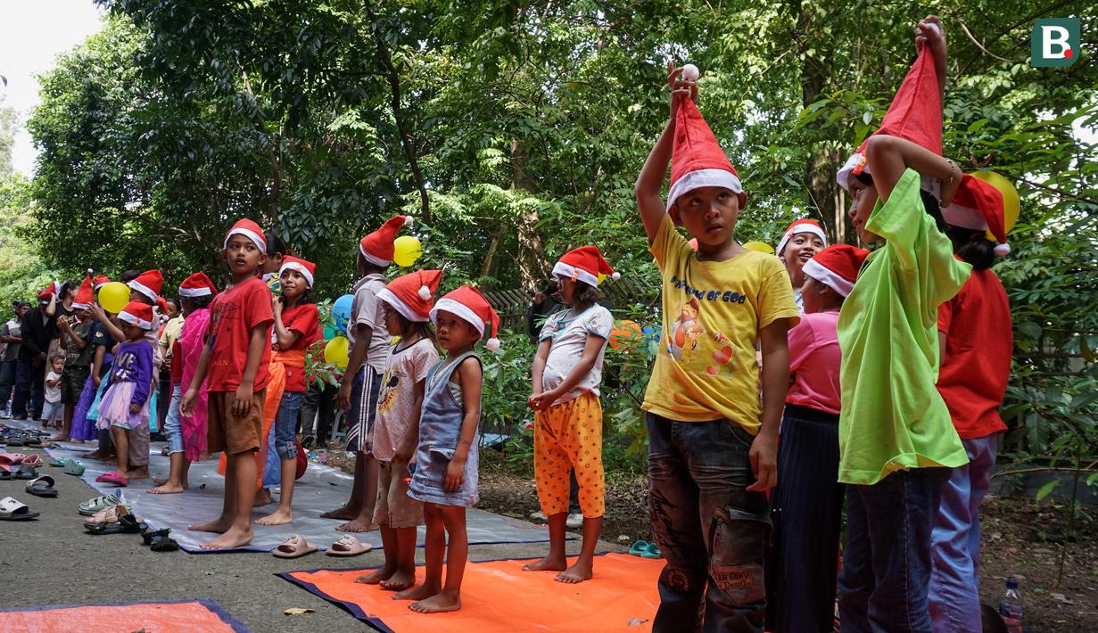 Anak-anak hingga orang tua menyambut acara tersebut dengan ceria. Mereka juga merias diri dengan mengenakan topi ala Santa Claus. (Bola.com/Bagaskara Lazuardi)