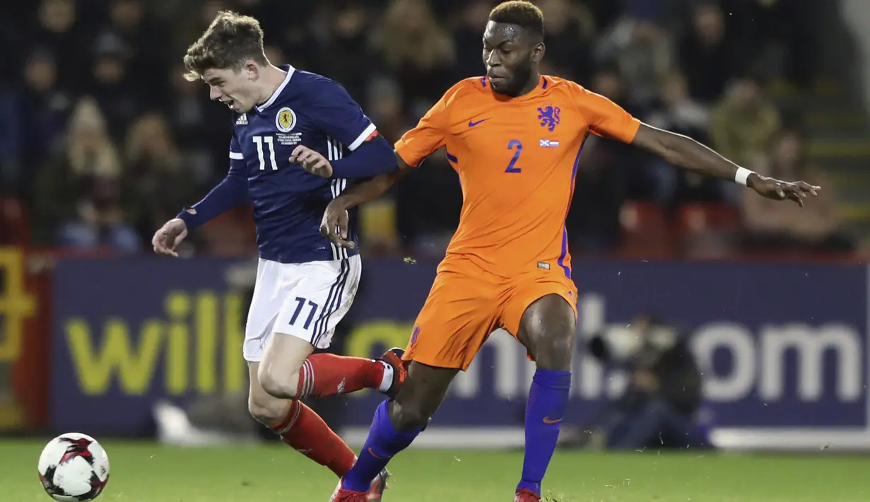 Pemain Skotlandia, Ryan Christie (kiri) mencoba melewati adangan pemain Belanda, Timothy Fosu-Mensah pada laga persahabatan di Pittodrie, Aberdeen, Skotlandia (9/11/2017). Belanda menang 1-0. (Andrew Milligan/PA via AP)