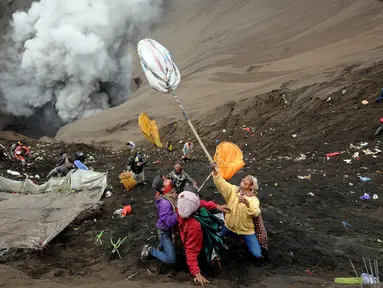 Warga berebut uang dan hasil bumi yang dilemparkan dari bibir kawah Gunung Bromo, Probolinggo, Kamis (21/7). Warga Tengger melakukan ritual lempar hasil bumi sebagai wujud syukur pada Sang Hyang Widi. (Liputan6.com/Helmi Fithriansyah)