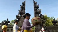 Sejumlah wanita Hindu membawa sesajen menuju pura untuk sembahyang Hari Raya Galungan di Jimbaran, Bali, Rabu (5/4). Galungan dirayakan oleh umat hindu di Bali sebagai hari kemenangan Dharma (Kebaikan) melawan Adharma (Keburukan). (SONNY TUMBELAKA/AFP)