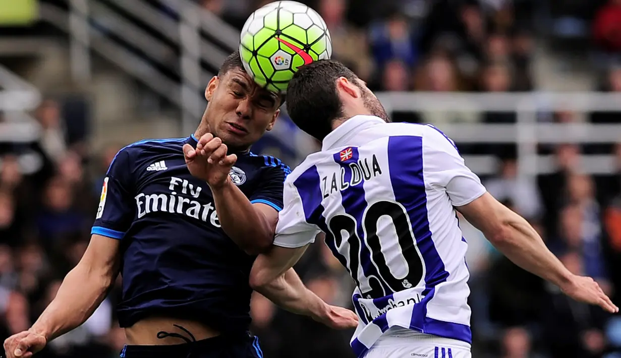 Pemain Real Madrid, Casemiro (kiri), duel dengan pemain Real Sociedad, Joseba Zaldua, dalam laga La Liga Spanyol di Stadion Anoeta, Sabtu (30/4/2016) malam WIB. (AFP/Ander Gillenea)