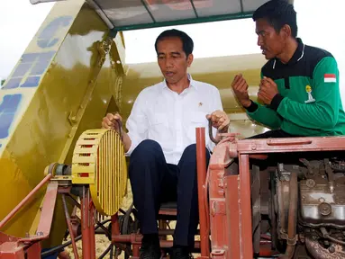 Presiden Jokowi mencoba mengoperasikan mesin panen padi buatan warga setempat di Kabupaten Pinrang, Sulawesi Selatan, Rabu (5/11/2014). (Rumgapres/Agus Suparto)