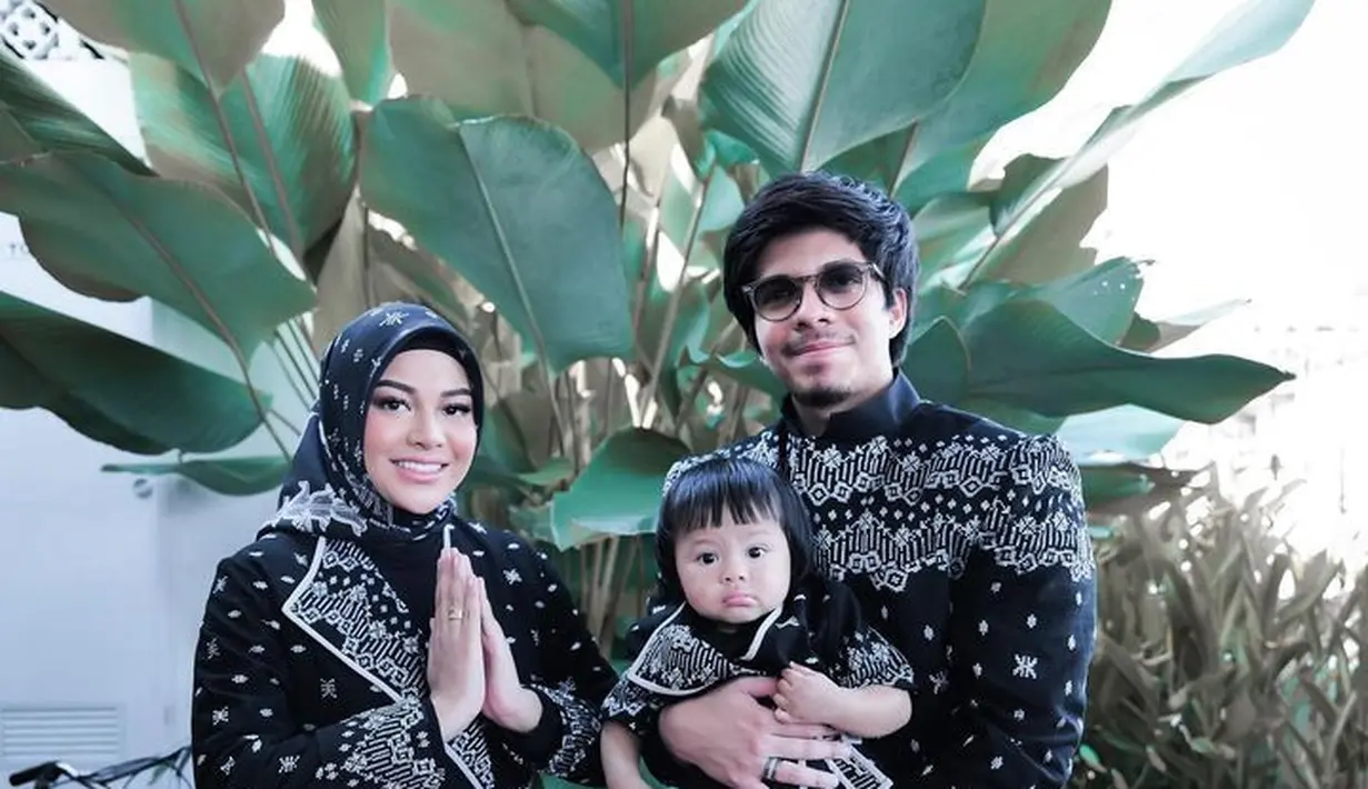 Model baju Lebaran keluarga Aurel dan Atta juga mengusung warna hitam. Aurel memakai baju dengan siluet coat berkerah dan bertali. [Foto: @attahalilintar]