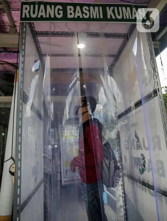 Calon penumpang berada di dalam bilik disinfektan di Halte Transjakarta Harmoni, Jakarta, Selasa (7/4/2020). Pemasangan bilik disinfektan tersebut sebagai upaya pencegahan penyebaran virus Corona COVID-19 di lingkungan Halte Transjakarta. (Liputan6.com/Faizal Fanani)