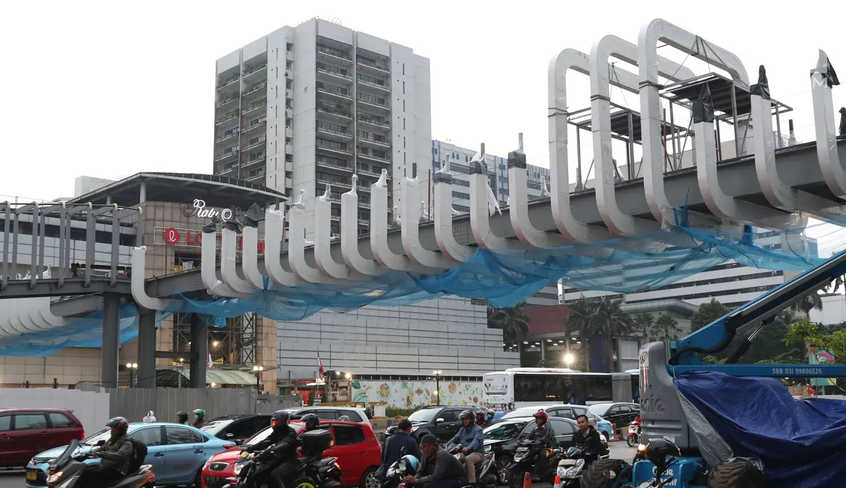 Pengendara melintas di bawah JPO Ratu Plaza di Jalan Jenderal Sudirman, Jakarta, Selasa (11/12). JPO Ratu Plaza merupakan 1 dari 12 JPO di sepanjang jalan Jend Sudirman - MH Thamrin yang masuk dalam proses revitalisasi. (Liputan6.com/Helmi Fithriansyah)