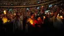Sekitar 16.000 jemaat dari wilayah Jabodetabek memadati arena untuk mengikuti ibadah tersebut. Tampak dalam foto, orang-orang memegang lilin elektrik sambil bernyanyi selama kebaktian Malam Natal di Indonesia Arena, Kompleks Gelora Bung Karno, Jakarta, Rabu 24 Desember 2025. (AP Photo/Tatan Syuflana)