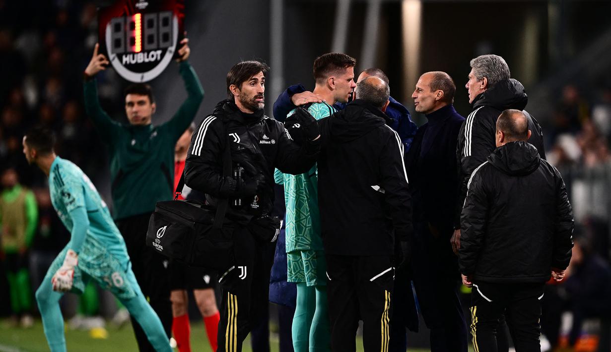 Kiper Juventus, Wojciech Szczesny digantikan Mattia Perin setelah mengalami sakit dada ketika pertandingan leg pertama perempat final Liga Europa 2022/2023 melawan Sporting CP di Allianz Stadium, Turin, Jumat (14/04/2023). Szczesny diketahui terkena paltisipasi jantung atau kondisi di mana seseorang merasakan kerja jantung yang kuat, cepat, atau tidak teratur. (AFP/Marco Bertorello)