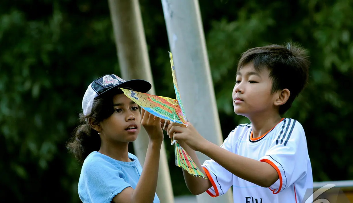 Dua orang bocah sedang memperbaiki mainan mereka di acara "Save Our   Children", Jakarta, Minggu (23/11/2014) (Liputan6.com/Faisal R Syam)