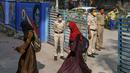 Polisi berjaga-jaga ketika siswa sekolah menengah negeri dan perguruan tinggi pra-universitas untuk wanita memasuki tempat institut pendidikan di Bangalore (16/2/2022). (AFP/Manjunath Kiran)