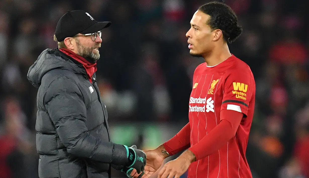 Pelatih Liverpool, Juergen Klopp, bersalaman dengan Virgil Van Dijk usai mengalahkan Brighton pada laga Premier League di Stadion Anfield, Liverpool, Sabtu (1/12). Liverpool menang 2-1 atas Brighton. (AFP/Paul Ellis)