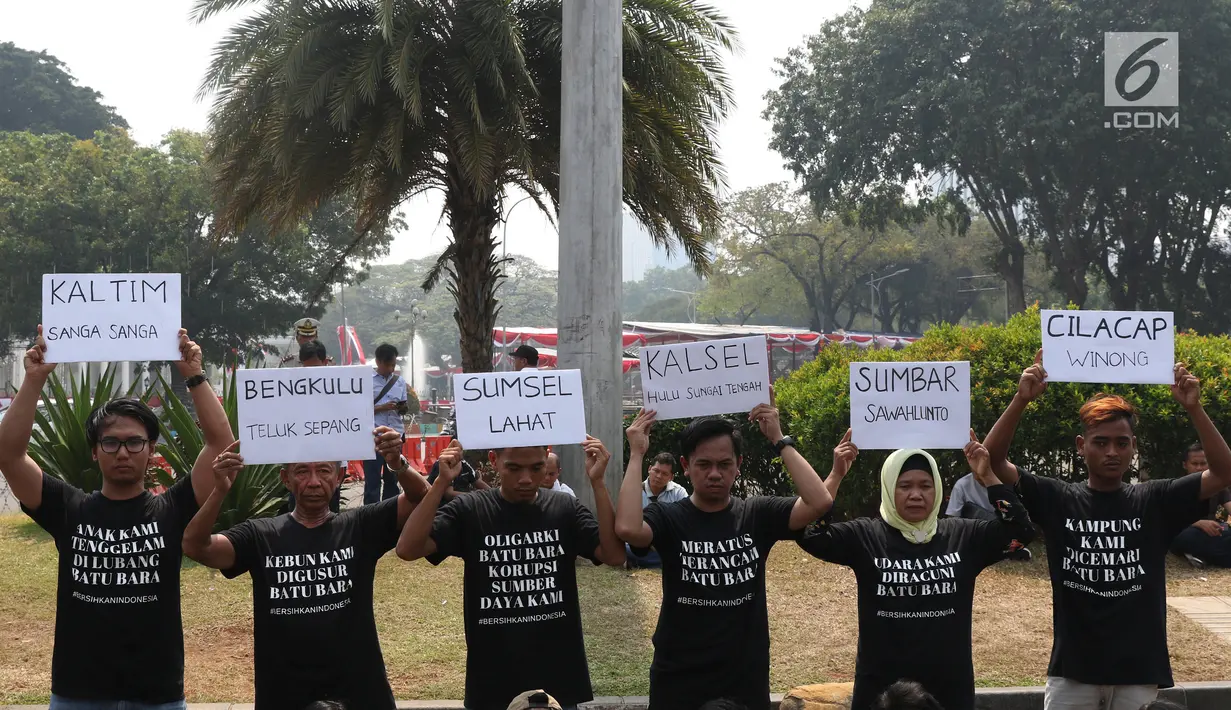 Aktivis menunjukkan pesan tuntutan saat menggelar aksi #BersihkanIndonesia di depan Istana Merdeka, Jakarta, Senin (19/8/2019). Aktivis menyerukan kebebasan hakiki dari kerusakan lingkungan dengan meninggalkan sumber energi fosil beralih ke energi bersih terbarukan. (Liputa6.com/Angga Yuniar)