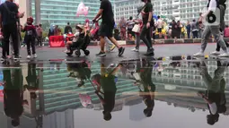 Warga berolahraga saat CFD di kawasan Bundaran HI, Jakarta, Minggu (3/7/2022). Meski sempat diguyur hujan tidak menyurutkan  masyarak untuk berolahraga di akhir pekan. (Liputan6.com/Angga Yuniar)