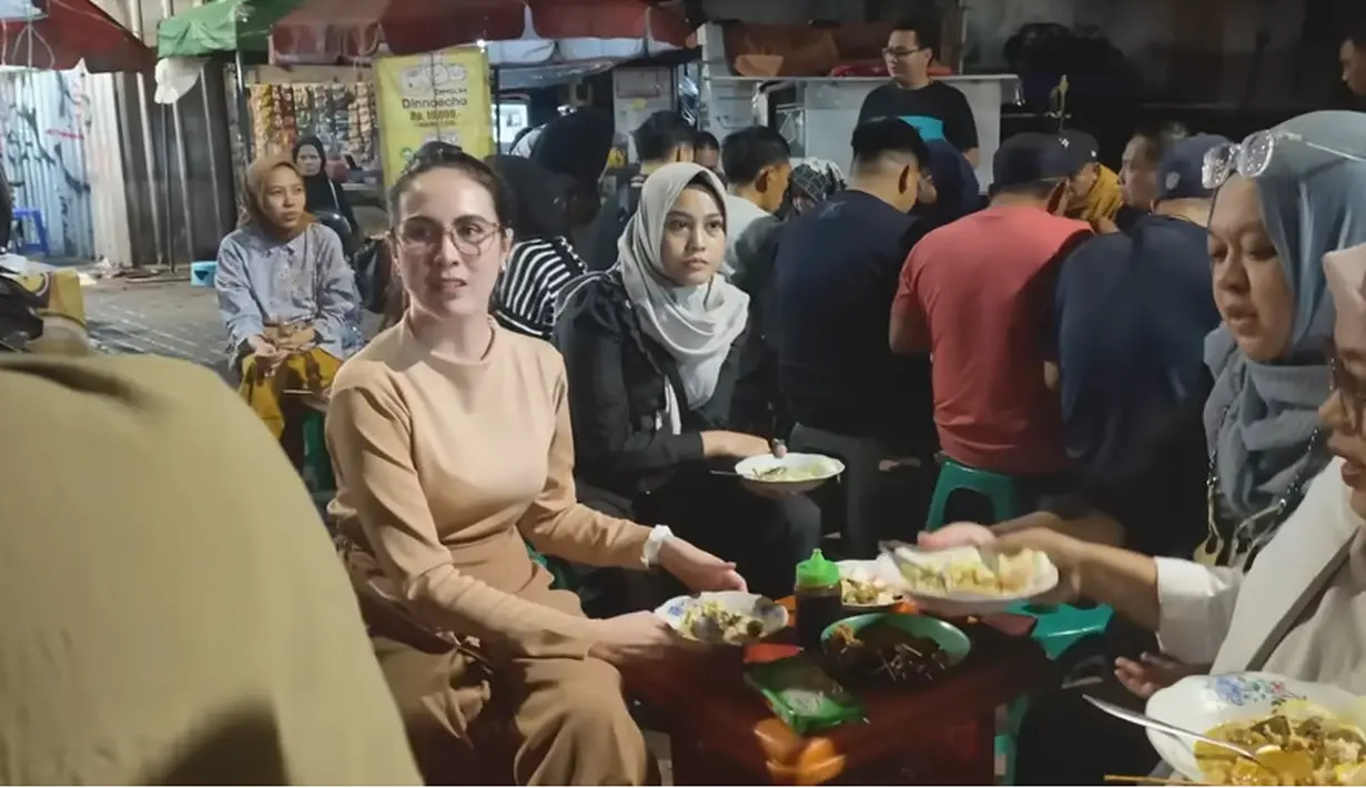 Arumi dan beberapa timnya tampak santai menikmati kulineran di pinggir jalan. Arumi mengaku kangen dengan kulineran seperti saat masih remaja. [Youtube/arumibachsin_94]