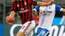 Penyerang AC Milan, Fabio Borini berusaha membawa bola dari kawalan pemain U Craiova, Alexandru Mateiu saat bertanding di leg kedua babak 3 Liga Europa di San Siro, Milan, (3/8). AC Milan sukses menang 2-0 atas Craiova. (AP Photo/Antonio Calanni)