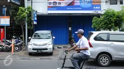 Pengendara sepeda melintas di depan sebuah bank yang ditutup di Jalan Agus Salim Jakarta, Kamis (14/1). Pasca ledakan di pos polisi dekat Gedung Sarinah, sejumlah toko dan kantor di sekitar lokasi berhenti beroperasi.  (Liputan6.com/Helmi Fithriansyah)