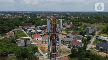 Foto udara teknisi melakukan pemeliharaan tower BTS 4G XL Axiata di Kuta Raya, Kayu Agung, Ogan Komering Ilir (OKI), Sumatera Selatan. Senin (13/3/2023). XL Axiata memastikan jaringan miliknya siap melayani kebutuhan pelanggan dan masyarakat selama Ramadhan hingga Hari Raya Idul Fitri 1444 Hijriah. (Liputan6.com/Herman Zakharia)