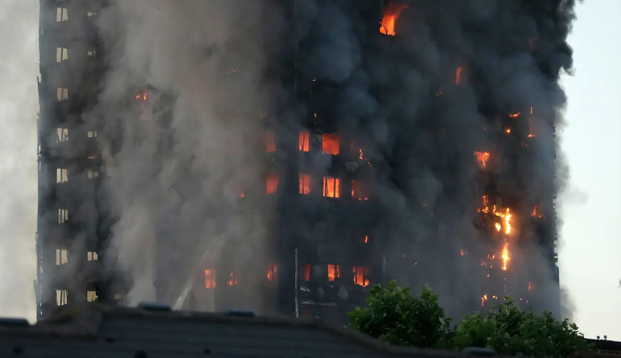 Sebuah gedung apartemen bertingkat 27 lantai yang terbakar di London (14/6). Sebanyak 200 pemadam kebakaran dikerahkan ke lokasi bersama 40 unit mobil pompa air. (AP Photo/Matt Dunham)
