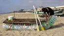Nelayan Palestina, Mouad Abu Zeid memperbaiki perahunya yang terbuat dari botol plastik bekas di pantai Rafah, Jalur Gaza, 14 Agustus 2018. Zeid menyulap ratusan botol plastik bekas menjadi perahu untuk melaut demi menghidupi keluarganya (AFP/SAID KHATIB)