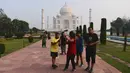 Turis mengabadikan foto saat mengunjungi Taj Mahal di Agra, India pada Senin (21/9/2020). Taj Mahal kembali dibuka untuk umum dalam gerakan simbolis seperti biasa, bahkan ketika India tampaknya akan mengambil alih AS sebagai pemimpin global dalam infeksi Virus Corona COVID-19. (Sajjad HUSSAIN/AFP)
