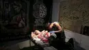 Seorang wanita terbaring saat di tato oleh seniman selama acara Festival Tato Internasional di Sochi, Rusia, (23/4). Sejumlah wanita tampak antusias untuk mentato tubuhnya di festival tato terbesar di negara tersebut. (REUTERS/Kazbek Basayev)