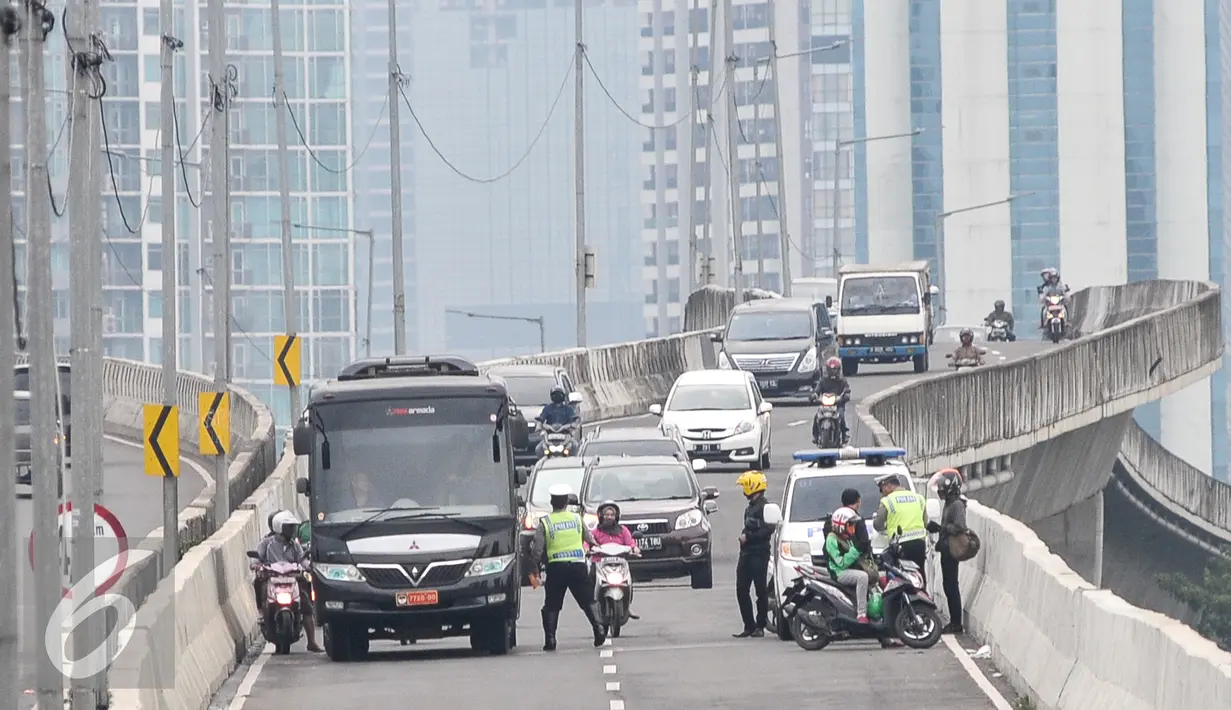 Petugas Kepolisan melakukan penindakan kepada pengedara motor yang memasuki JLNT Kampung Melayu - Tanah Abang di Jakarta, Senin (31/10). Karena kondisi angin diatas jembatan kencang dapat membahayakan pengendara sepeda motor. (Liputan6.com/Yoppy Renato)