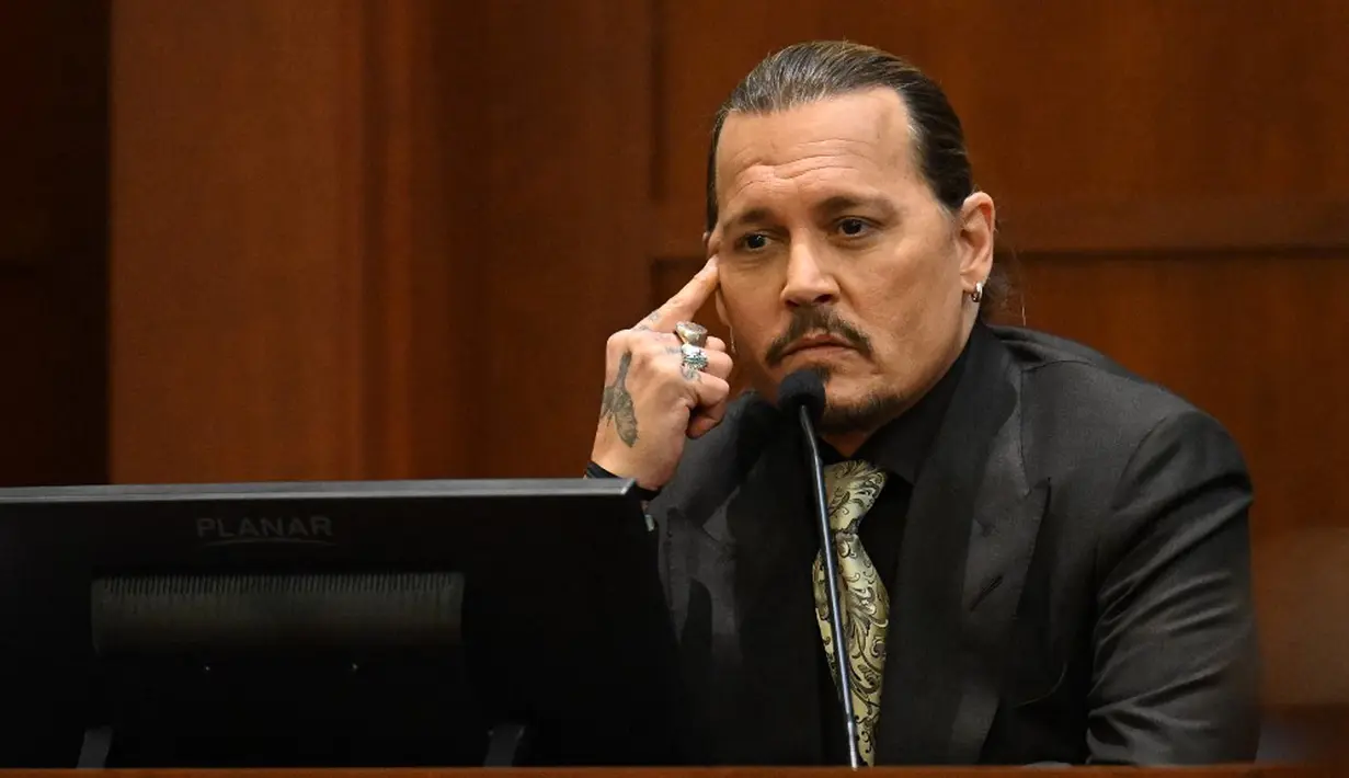 Aktor Johnny Depp bersaksi pada persidangan pencemaran nama baik di Fairfax County Circuit Courthouse, Fairfax, Virginia, Amerika Serikat, 19 April 2022. Johnny Depp menggugat Amber Heard setelah dia menulis artikel opini di The Washington Post pada tahun 2018. (JIM WATSON/POOL/AFP)