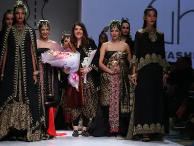 Ghea Panggabean diantara model yang mengenakan busana rancangannya di  Ikatan Perancang Mode Indonesia (IPMI) Trend Show 2017, Jakarta, Selasa (8/11). Ghea memadukan Budaya Sumatra dan Jawa dalam rancangannya kali ini. (Liputan6.com/Gempur M Surya)
