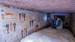 Seorang arkeolog berbicara kepada anggota media di dalam makam Beti, salah satu dari lima makam Firaun kuno di situs arkeologi Saqqara, Kairo, Mesir (19/3/2022). Para arkeolog menemukan lima makam di timur laut piramida Raja Merenre I, yang memerintah Mesir sekitar tahun 2270 SM. (AFP/Khaled Desouki