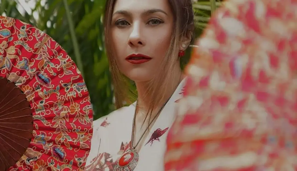 Serta pulasan makeup bold dengan lipstik merah yang membuat pesonanya semakin memikat. [@theomono/@wulanguritno].