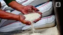 Pekerja menunjukkan beras yang akan dijual di toko beras di Pasar Kebayoran Lama, Jakarta, Jumat (5/5/2023). Kenaikan harga beras menjadi salah satu penyumbang inflasi Indeks Harga Konsumen pada April 2023. (Liputan6.com/Angga Yuniar)