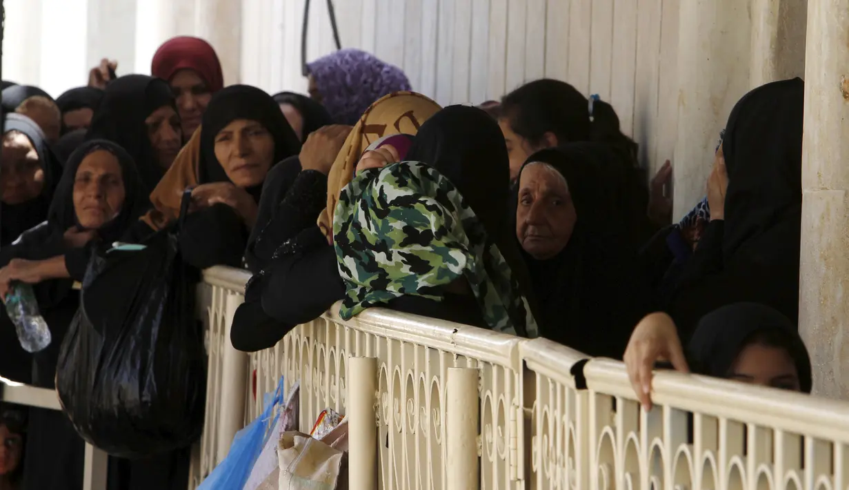 Sejumlah perempuan muslim saat antre untuk mengambil makanan buka puasa gratis yang didistribusikan bagi yang membutuhkan selama bulan puasa di masjid Abdul Qadir al-Gailani, Baghdad, Rabu (24/6/2015). (REUTERS/Khalid al-Mousily)