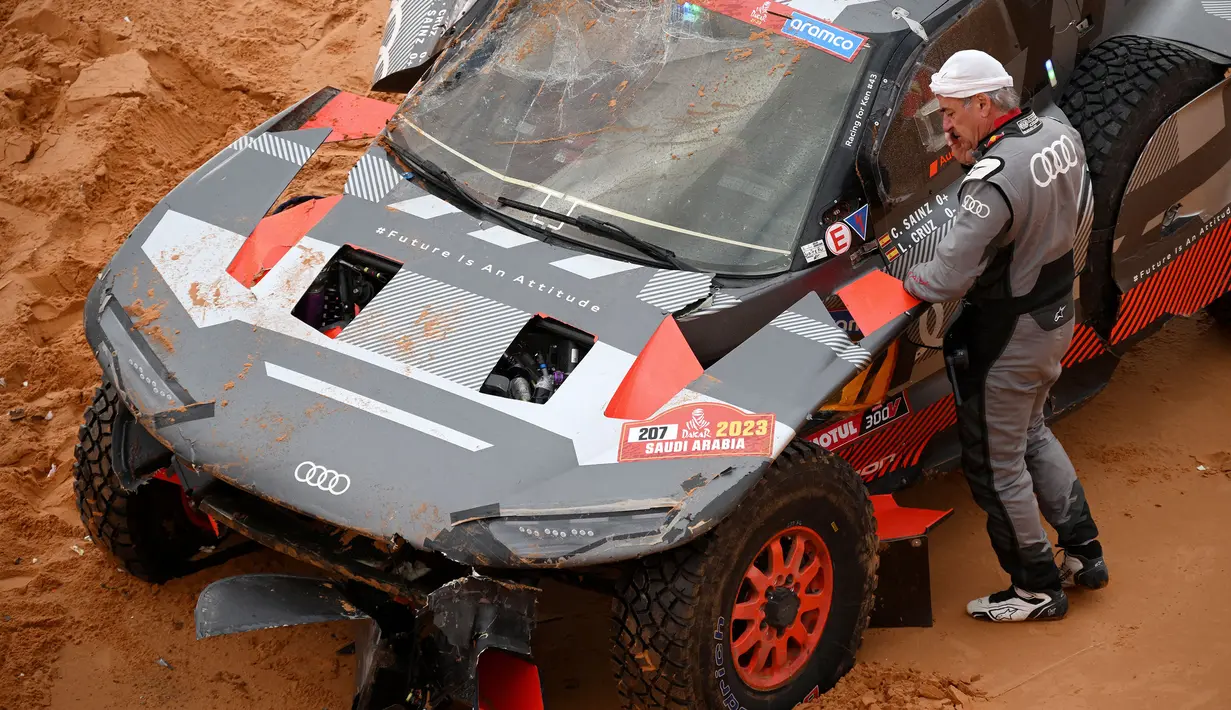 Luca Cruz yang dibantu oleh mekanik Audi berusaha memperbaiki mobil agar Sainz bisa melanjutkan balapan. (AFP/Franck Fife)