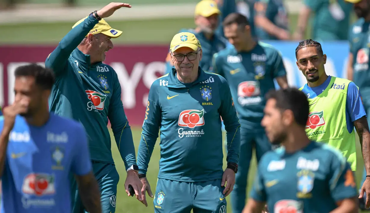 Pelatih kepala Tim Nasional (Timnas) Brasil asal Italia, Carlo Ancelotti (tengah), tersenyum di samping penyerang Raphinha (kanan) selama sesi latihan sebagai bagian dari persiapan menghadapi pertandingan sepak bola Piala Dunia 2026 melawan Maroko di Fasilitas Latihan Columbia Park, Morristown, New Jersey, pada 9 Juni 2026. (MAURO PIMENTEL/AFP)