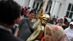 Kawasan Kota Tua Jakarta masih menjadi lokasi wisata favorit warga Jakarta, Jumat (26/12/2014). Salah satu pengunjung berfoto bersama manusia patung di kawasan Kota Tua Jakarta. (Liputan6.com/Faizal Fanani)