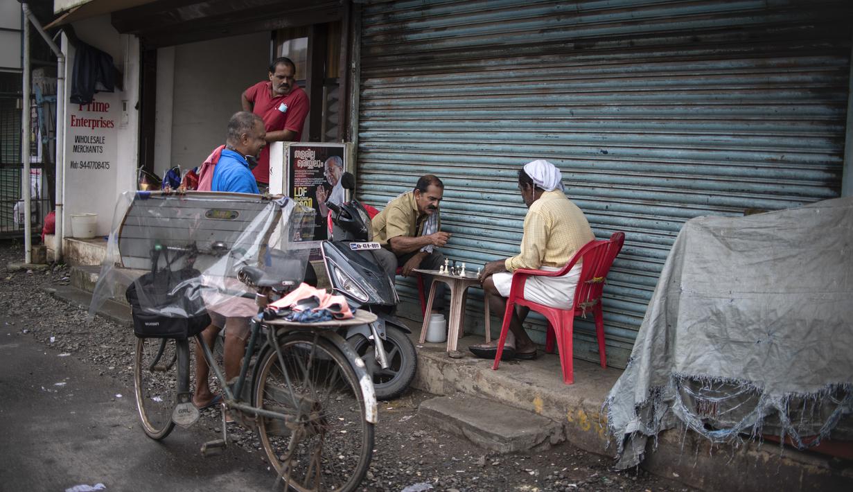 Dua pria bermain catur di pagi hari di luar toko yang tutup di pasar grosir di Kochi, negara bagian Kerala, India, Rabu (6/7/2022). Negara bagian selatan itu telah mewajibkan penggunaan masker di tempat-tempat umum menyusul meningkatnya kasus COVID-19. (AP Photo/ RS Iyer)