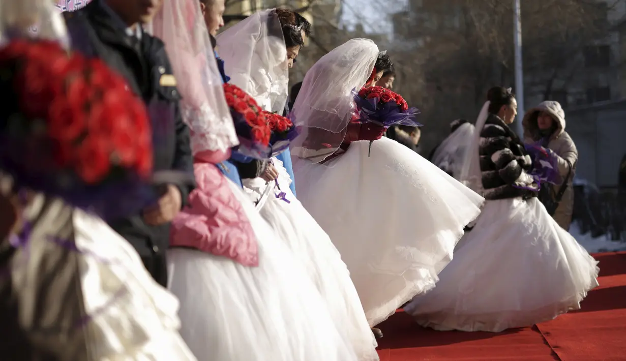 Sejumlah pasangan pengantin baru ikut ambil bagian dalam upacara pernikahan massal di tengah-tengah Festival Es dan Salju Harbin di provinsi Heilongjiang, China, Rabu (6/1/2016). ( REUTERS/ Aly Song)