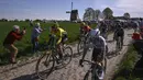 Pembalap Team Visma-Lease, Pauline Ferrand-Prevot (kiri) berkompetisi dalam ajang balap sepeda Paris Roubaix Femmes 2025 pada Sabtu (12/04/2025) waktu setempat. Perlombaan tersebut menempuh 148,5 km dari Denain hingga Roubaix, Prancis. (AFP/Julien De Rosa)