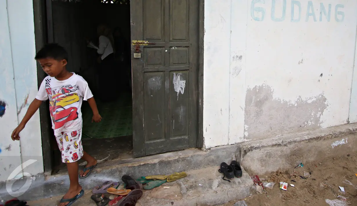 Seorang siswa SD mengikuti kegiatan belajar di Sekolah Terbuka, Kampung Manggar, Balikpapan, Kaltim, Kamis (29/10). Minimnya fasilitas, membuat kegiatan belajar terpaksa dilakukan di gudang bekas penyimpanan rumput laut. (Liputan6.com/Immanuel Antonius)
