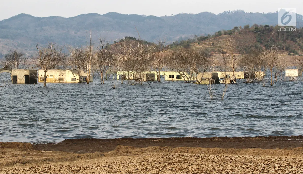 Sejumlah rumah muncul ke permukaan Waduk Jatigede, Desa Cipaku, Sumedang, Jawa Barat, Senin  (17/9). Musim kemarau panjang menyebabkan Waduk Jatigede surut sehingga puing bangunan Desa Cipaku yang tenggalam kembali terlihat. (Liputan6.com/Herman Zakharia)