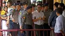 Wartawan Reuters, Wa Lone (tengah) dikawal oleh polisi setibanya di pengadilan distrik Yangon, Myanmar, Senin (3/9). Dua jurnalis Reuters dituduh melanggar undang-undang rahasia negara saat menyelidiki kekerasan terhadap Rohingya. (AP/Thein Zaw)