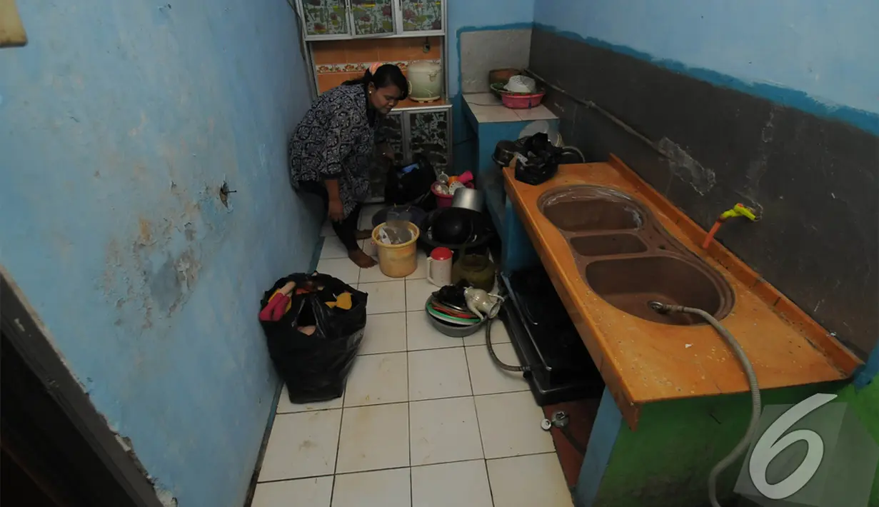 Ibunda Sony Wakwaw sedang membereskan barang-barang di dapur saat tiba di rumah baru mereka di kawasan Cibubur, Jakarta Timur. Foto diambil pada Kamis (4/12/2014). (Liputan6.com/Herman Zakharia)